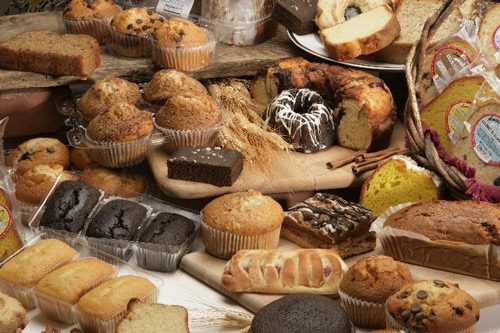 A spread of Fernando's Bakery muffins, loaves, cakes, and pastries.
