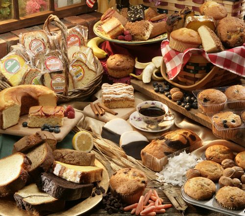A table of Fernando's Bakery muffins, cakes, slices, and pastries.